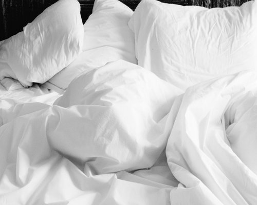A cozy bed with soft linens indicating restful sleep